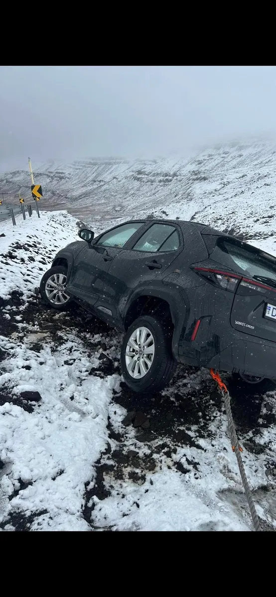 Toyota Yaris Cross í snjó við vegkant, með dráttartaug festa við bílinn