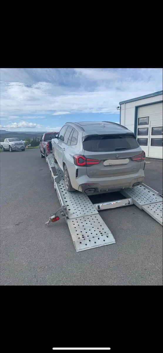 BMW X3 á bílaflutningakerru fyrir utan verkstæði